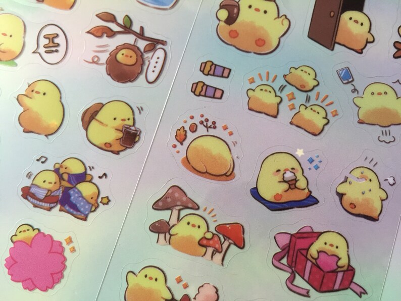 以下が含まれることがあります： 様々なポーズと設定で描かれた、黄色いヒヨコの漫画のステッカーのシート。ステッカーには、コーヒーカップを持ったヒヨコ、着物姿のヒヨコ、箱に座っているヒヨコ、キノコに座っているヒヨコなどが含まれています。これらのステッカーは、プランナー、ジャーナル、またはラップトップに遊び心のあるタッチを加えるのに最適です。