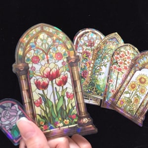 May include: A set of six iridescent stickers featuring stained glass window designs. The designs include flowers, sunflowers, and a rose.