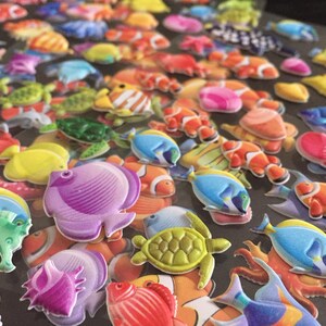 Puede incluir: Una colecci&oacute;n de pegatinas de espuma 3D de colores que representan diversas criaturas marinas, como peces, caballitos de mar, tortugas y conchas. Las pegatinas son perfectas para a&ntilde;adir un toque caprichoso a las manualidades, los diarios y otros proyectos.