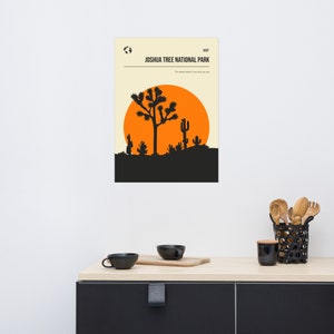 May include: A minimalist poster with a black silhouette of a Joshua Tree and a large orange sun against a cream background. The text "Joshua Tree National Park" is in black at the top of the poster.