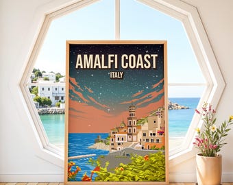 May include: A framed art print featuring the Amalfi Coast in Italy. The artwork depicts a coastal town with buildings, a tower, and the text "Amalfi Coast Italy" against a starry sky. The print is displayed near a window with a view of the ocean.