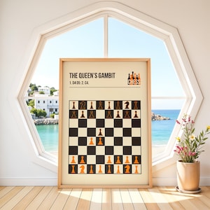 Puede incluir: Un póster enmarcado que muestra un tablero de ajedrez con las piezas dispuestas para la apertura del Gambito de Dama. El póster tiene un fondo beige con piezas de ajedrez negras y naranjas. El título "THE QUEEN'S GAMBIT" está en la parte superior, con la palabra "CHESS" en naranja.