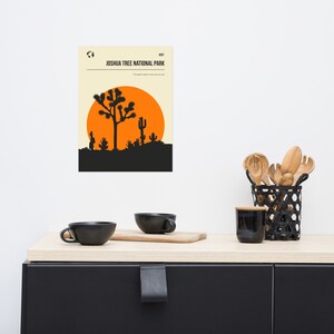 May include: A minimalist poster with a black silhouette of a Joshua Tree and cacti against an orange sunset. The text "VISIT JOSHUA TREE NATIONAL PARK" is at the top of the poster. The text "The desert doesn't care why you are here" is below the image.