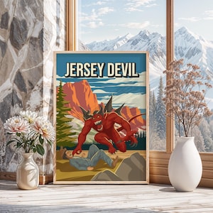 Op de afbeelding: Een ingelijste poster met de tekst "JERSEY DEVIL" toont een rode duivelsfiguur die een persoon aanvalt. De achtergrond omvat bergen, bomen en een blauwe lucht. De poster staat in een houten lijst, in de buurt van een raam.