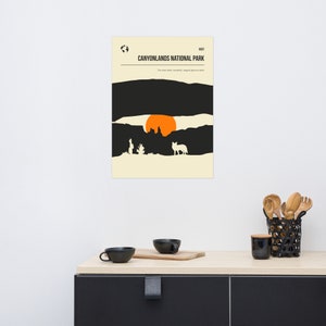 Może przedstawiać: Minimalistyczny plakat z czarno-białą ilustracją zachodu słońca nad kanionem z sylwetką kojota na pierwszym planie. Tekst "Canyonlands National Park" znajduje się na g&oacute;rze plakatu.