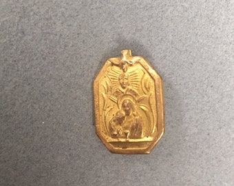 May include: A gold-colored metal pendant with a religious image of a woman and child. The pendant is octagonal in shape and has a raised design.