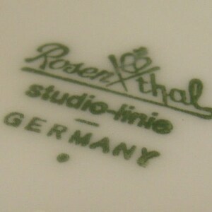 Może przedstawiać: Zbliżenie zielono-białego logo z napisem "Rosenthal studio-linie GERMANY".