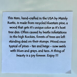 May include: A white paper with black text describing a product made from recycled bluestain pine. The text mentions the unique colors of the wood, caused by beetle infestations in the Rockies.