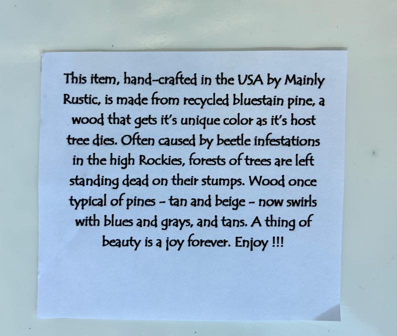 May include: A white paper with black text describing a product made from recycled bluestain pine. The text mentions the unique colors of the wood, caused by beetle infestations in the Rockies.