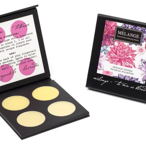 May include: A black box with four round, yellow solid perfume samples. The box is open and the inside lid has instructions for using the perfume. The text on the lid reads "be creative: wear any Melange solid fragrance alone, or blend 2, 3 or all notes together to create your own very unique fragrance. use: with the back of your fingernail remove perfume, apply to wrist (warn by rubbing them together) and apply to desired area - honeysuckle lavender". The box is labeled "MELANGE Solid Perfume & Blending Palette SINGLE NOTES FLORAL PALETTE mélange - to mix or blend".