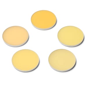 May include: Five round, yellow cosmetic pans with white rims are arranged on a white background. The shades of yellow vary from light to a deeper, golden hue. The pans are evenly spaced, creating a visually appealing arrangement.