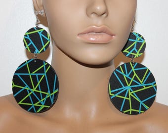 May include: A pair of large, round earrings with a black background and a geometric pattern of green and blue lines.
