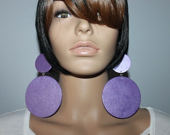 May include: A pair of large, round, purple earrings. The earrings are made of wood and have a shimmery finish.
