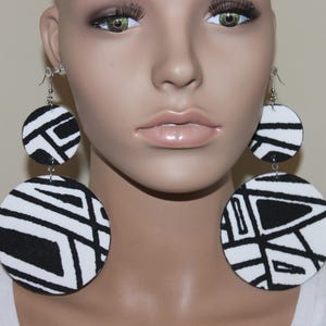 May include: A white ceramic mug with a black handle and the text "But First, Coffee" in a black, bold font. The mug is on a white surface.