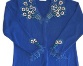 Detailed Storybook Knits handmade Peacock sweater. Blue, gossamer eyelash yarn fringe edging. Stylized feathers. Bugle beads. Size 1X
