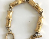 Vintage 1950s MONET gold-plated. florentined, textured, lucky bamboo link bracelet. DETAIL Bamboo-shaped toggle clasp. Monet hang tag. EUC