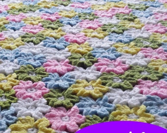 Puede incluir: Una manta de ganchillo con un patrón repetitivo de flores de colores en tonos de rosa, azul, amarillo y verde. La manta está hecha con un hilo suave y texturizado y tiene un toque delicado y femenino. El texto "crochets4u" es visible en la esquina inferior izquierda de la imagen. La palabra "pdf" está escrita en letras blancas sobre un óvalo morado.