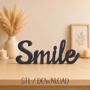 Op de afbeelding: Een zwart woordbord in cursief schrift dat "Smile" spelt in een vetgedrukt, verbonden lettertype. De letters zijn solide en staan rechtop op een plat oppervlak. Onder het bord staat de tekst "STL / DOWNLOAD" in een eenvoudig, zwart lettertype.
