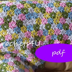 May include: A crocheted baby blanket with a flower pattern in shades of pink, blue, yellow, green, and white. The blanket is made with a simple stitch and has a soft, fluffy texture. The text "crochets4U pdf" is visible in the image.