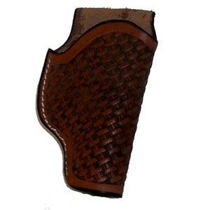 May include: A brown leather holster with a woven pattern. The holster has a white stitching detail around the edges.