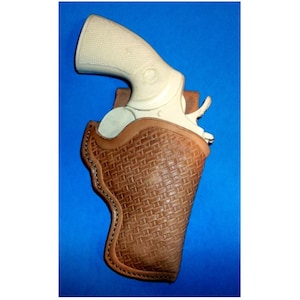 May include: A brown leather holster with a woven pattern, designed to hold a white revolver.
