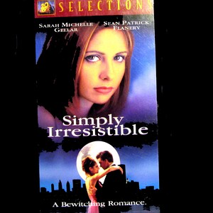 Puede incluir: Una cinta VHS de la película Simply Irresistible, con un retrato de Sarah Michelle Gellar y Sean Patrick Flanery. La portada incluye el texto 20th Century Fox Selections, Simply Irresistible y A Bewitching Romance sobre un fondo azul.