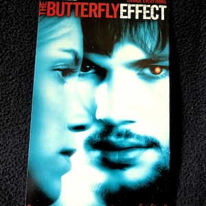 May include: A VHS tape cover for the film The Butterfly Effect featuring Ashton Kutcher and Amy Smart. The blue-toned artwork displays close-up faces with the text: Change one thing. Change everything. A complex and witheringly powerful film.