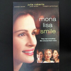 Puede incluir: Portada de la película "Mona Lisa Smile" con Julia Roberts. El título está en una fuente grande y estilizada. La portada incluye imágenes de otras actrices y el texto "They had everything. She showed them more."