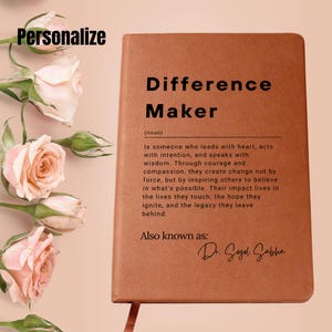 May include: A brown leather-bound journal with the words "Difference Maker" printed on the front. The journal has a definition of the term "Difference Maker" and the words "Also known as: Dr. Sogel Sabha" printed below the definition.