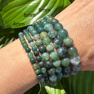 May include: A set of five green agate stone bracelets, each with a different size bead. The bracelets are labeled 4mm, 6mm, 8mm, 10mm, and 12mm.