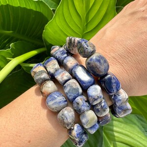 Peut inclure: Un ensemble de quatre bracelets en pierres pr&eacute;cieuses bleues et blanches. Les bracelets sont faits d'une pierre bleu clair, blanche et grise avec un motif mouchet&eacute;.