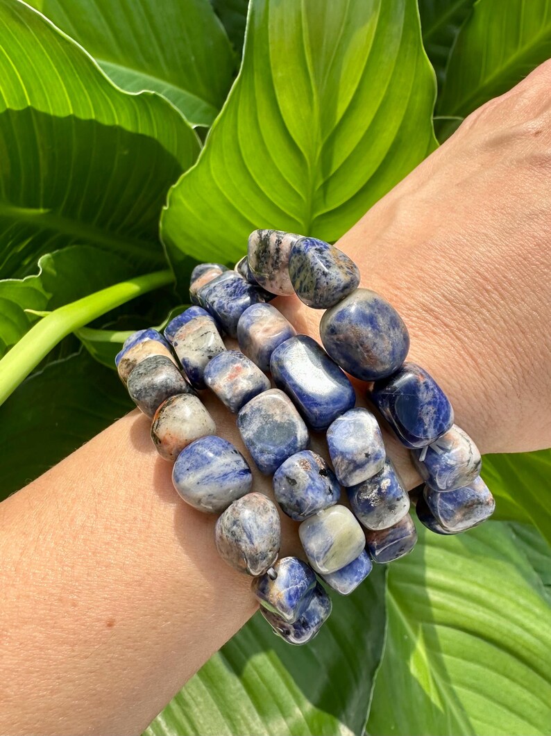 Peut inclure: Un ensemble de quatre bracelets en pierres pr&eacute;cieuses bleues et blanches. Les bracelets sont faits d'une pierre bleu clair, blanche et grise avec un motif mouchet&eacute;.