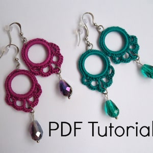 May include: A pair of crocheted earrings with a teardrop-shaped crystal pendant. The earrings are available in two colors: teal and magenta.
