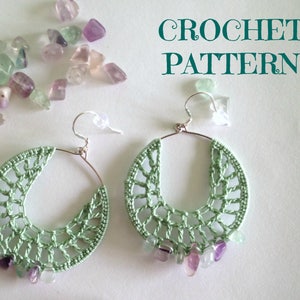 May include: A pair of crocheted earrings with green and purple gemstone accents. The earrings are made with a delicate crochet pattern and are a beautiful and unique piece of jewelry. CROCHET PATTERN is written on the background.