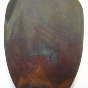 May include: A small, round, ceramic vase with a dark brown, purple, and blue glaze. The vase has a white rim around the top.
