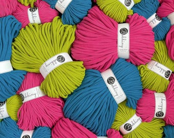 May include: A collection of colorful yarn skeins in shades of pink, blue, and green. Each skein is wrapped with a white label that reads "Bobbiny". The yarn appears to be a thick, soft material, suitable for various crafting projects.