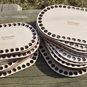 Könnte beinhalten: Ein Stapel ovaler Holz-Webrahmen mit Löchern an den Rändern. Die Rahmen werden von Leomaxi hergestellt und tragen den Schriftzug "Made in Germany".