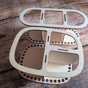 Op de afbeelding: Houten garenkom-organizer met twee lagen en meerdere compartimenten. De kom heeft een ronde vorm met een decoratief patroon rond de rand.