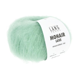 May include: A ball of soft, mint green mohair yarn. The label reads "LANG YARNS MOHAIR LUXE MOHAIR SUPERKID / SILK". The yarn has a fluffy, textured appearance, ideal for knitting or crocheting projects.