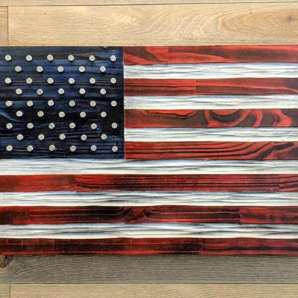 US Flag carved in wood with .40 nickel plated brass in place of the stars. Red, White and Blue colors unique chisel texture. Rustic flag.