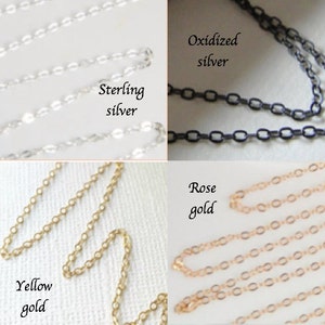 May include: Close-up of four different chain styles: sterling silver, oxidized silver, yellow gold, and rose gold. Each chain is displayed with its respective label. The chains are delicate and have a variety of link shapes.