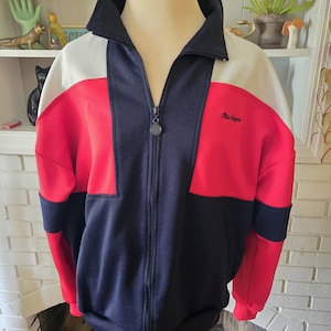 Könnte beinhalten: Eine schwarze, rote und weiße Colorblock-Jacke mit Reißverschluss, auf der rechten Brustseite ist das Wort "Marlboro" gestickt.