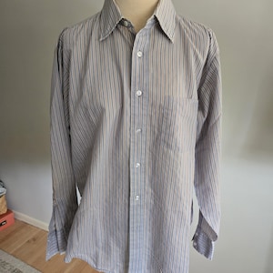 Op de afbeelding: Een set van drie keramische mokken met een gespikkelde, matte afwerking. De mokken zijn in de kleuren crème, lichtgrijs en donkergrijs. Elke mok heeft een eenvoudig, minimalistisch ontwerp en een afgeronde handgreep. De mokken zijn op elkaar gestapeld.