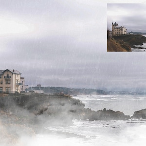 May include: A white building with a tower on a cliff overlooking a foggy ocean. The sky is gray and it is raining.