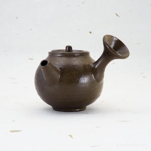 May include: A set of three ceramic mugs with a speckled, matte finish. The mugs are in shades of cream, light gray, and dark gray. Each mug has a simple, minimalist design, perfect for coffee or tea.