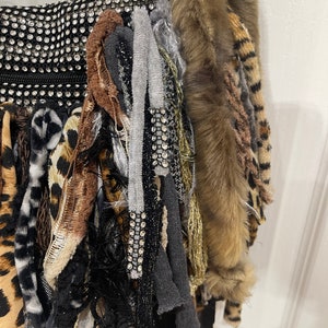 Puede incluir: Un bolso negro con una variedad de texturas y colores, incluyendo piel sint&eacute;tica, estampado de leopardo y pedrer&iacute;a.