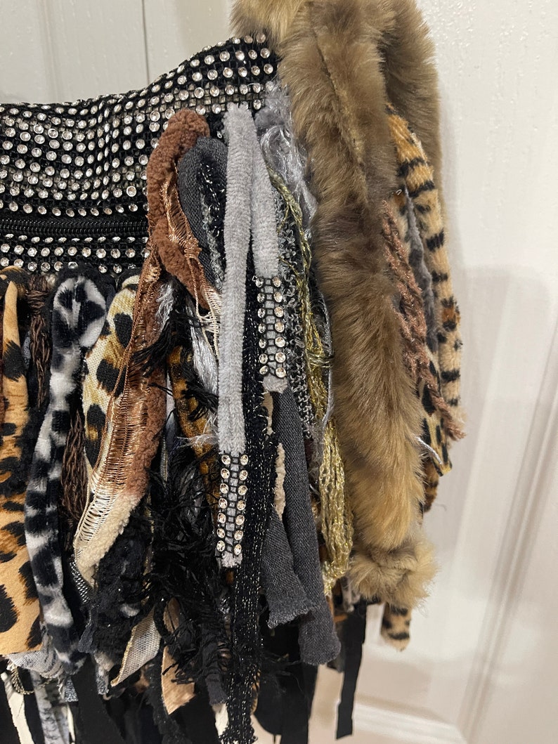 Puede incluir: Un bolso negro con una variedad de texturas y colores, incluyendo piel sint&eacute;tica, estampado de leopardo y pedrer&iacute;a.