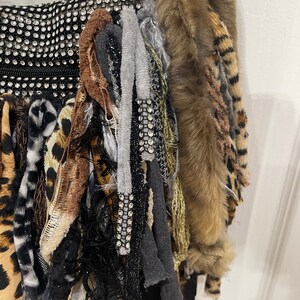 Puede incluir: Un bolso negro con una variedad de texturas y patrones, incluyendo piel sint&eacute;tica, estampado de leopardo y pedrer&iacute;a.