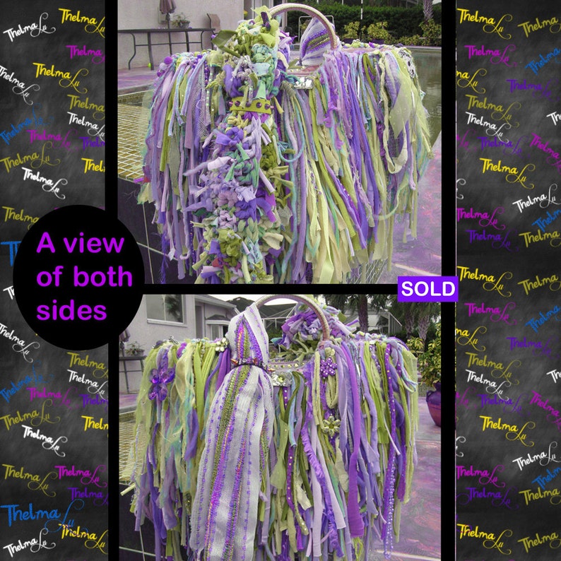 May include: A view of both sides of a purple, green, and white fabric handbag with a beaded strap. The bag is covered in strips of fabric and has a fringe-like appearance.