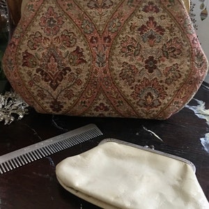 May include: A vintage floral patterned fabric clutch purse with a gold metal clasp and a separate white leather coin purse.